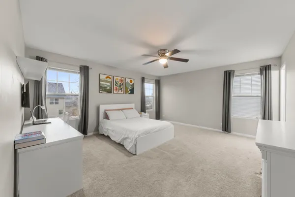 a bedroom with a large bed and a chandelier