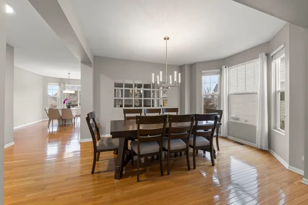 a view of a a dining room with furniture window and wooden floor