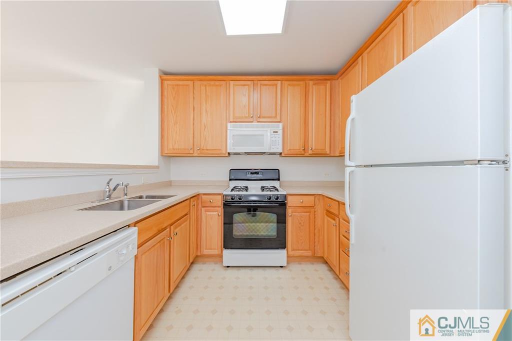368 Rector Street, Unit 411 Perth Amboy, NJ 08861 - Photo 6 of 14 a kitchen with stainless steel appliances granite countertop a refrigerator a sink dishwasher a stove with white cabinets and wooden floor