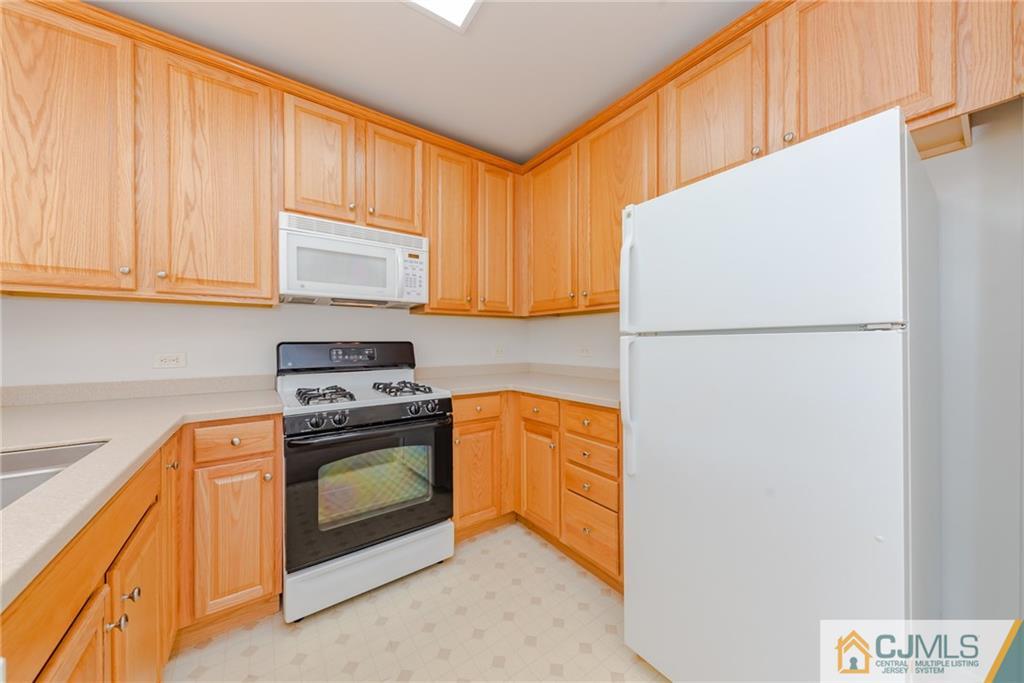 368 Rector Street, Unit 411 Perth Amboy, NJ 08861 - Photo 7 of 14 a kitchen with a refrigerator sink stove and cabinets