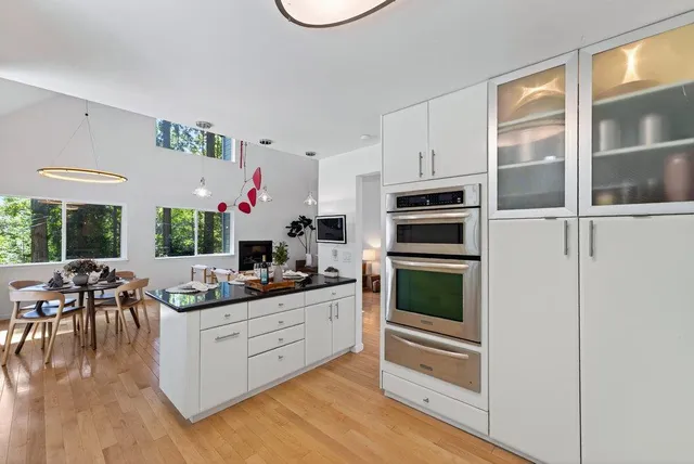 a kitchen with kitchen island granite countertop a stove and a refrigerator