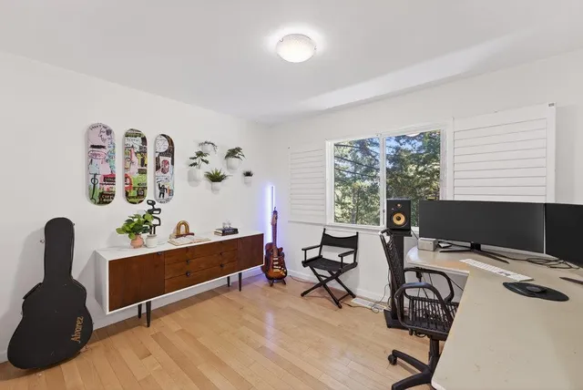 a view of a workspace with furniture and a window