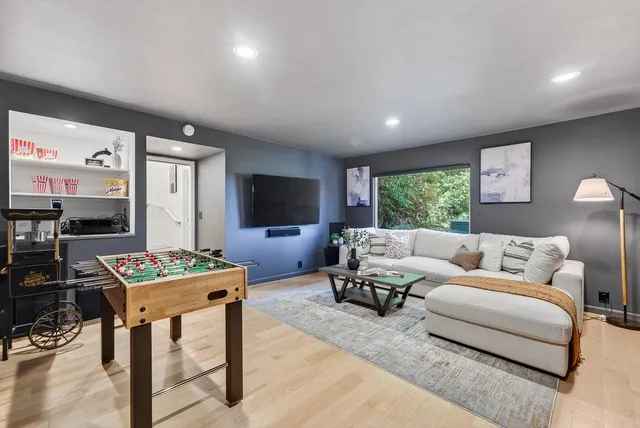 a living room with furniture a flat screen tv and a large window