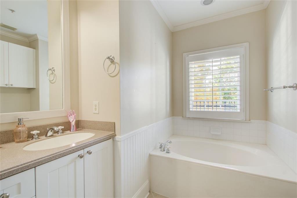 4100 Paces Walk Southeast, Unit 1306 Atlanta, GA 30339 - Photo 15 of 32 a bathroom with a tub sink and mirror