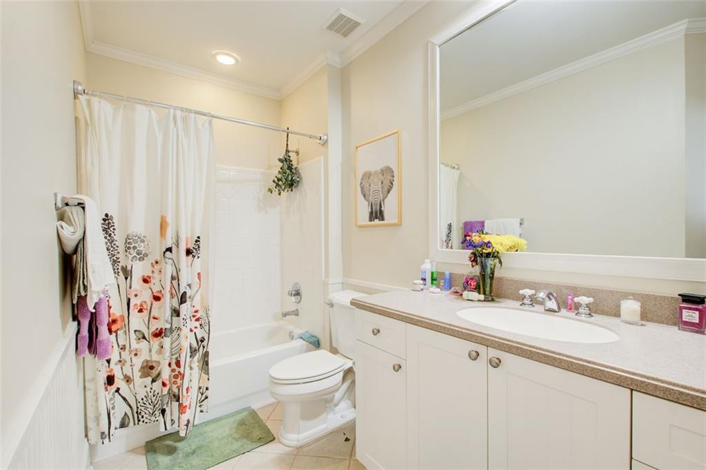4100 Paces Walk Southeast, Unit 1306 Atlanta, GA 30339 - Photo 23 of 32 a bathroom with a sink a toilet and shower curtain