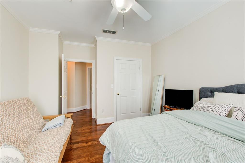 4100 Paces Walk Southeast, Unit 1306 Atlanta, GA 30339 - Photo 26 of 32 a bedroom with a bed and a chandelier