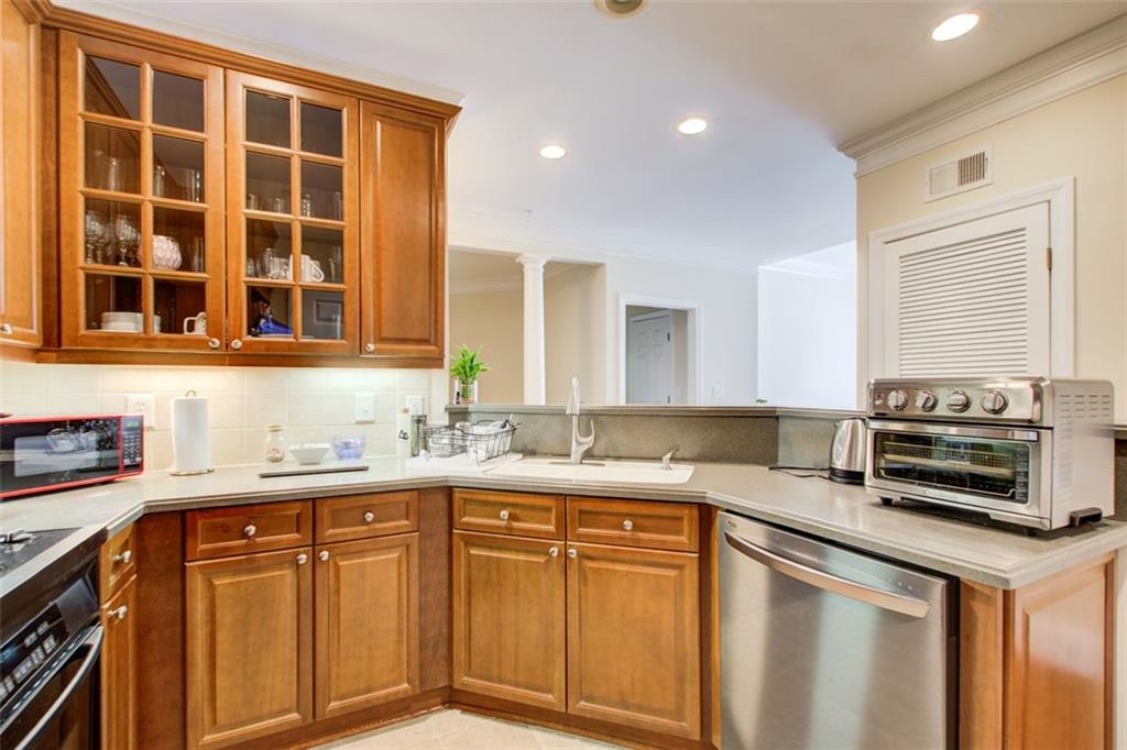 4100 Paces Walk Southeast, Unit 1306 Atlanta, GA 30339 - Photo 8 of 32 a kitchen with stainless steel appliances granite countertop a sink stove and cabinets