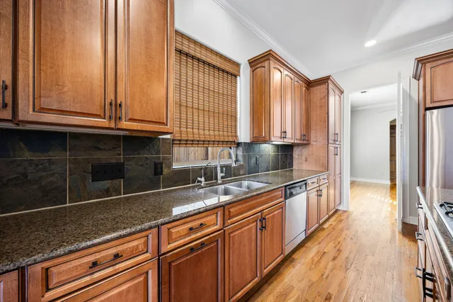 a kitchen with stainless steel appliances granite countertop a sink and a wooden cabinets