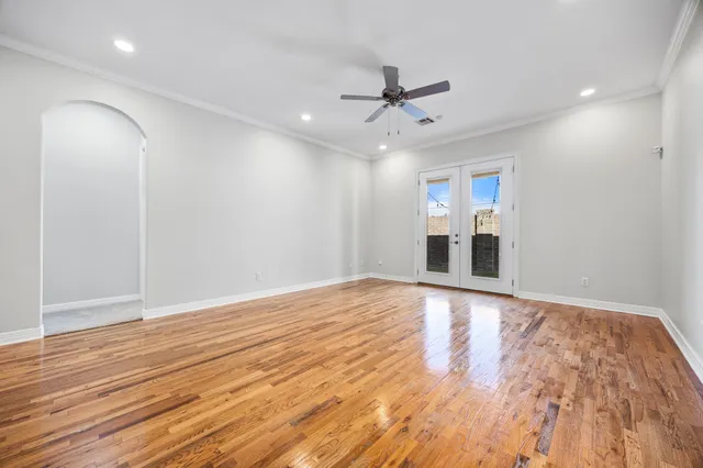a view of empty room with wooden floor and ceiling fan
