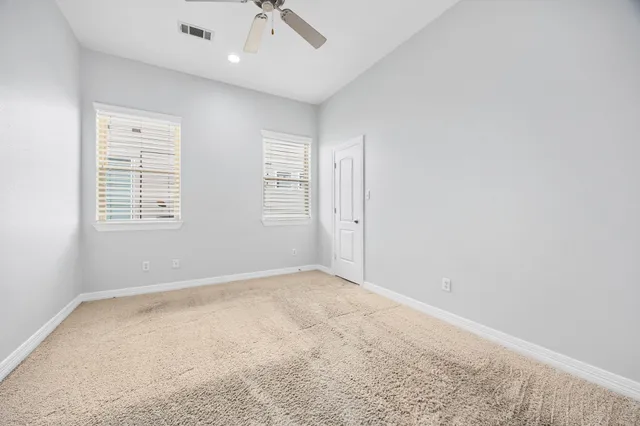 an empty room with a window and a ceiling fan