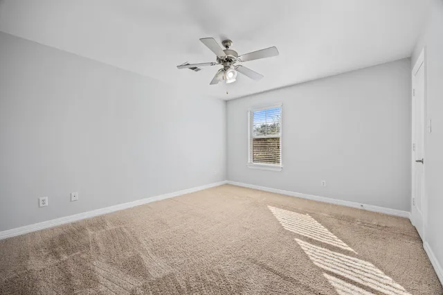 a view of a room with a ceiling fan and a window