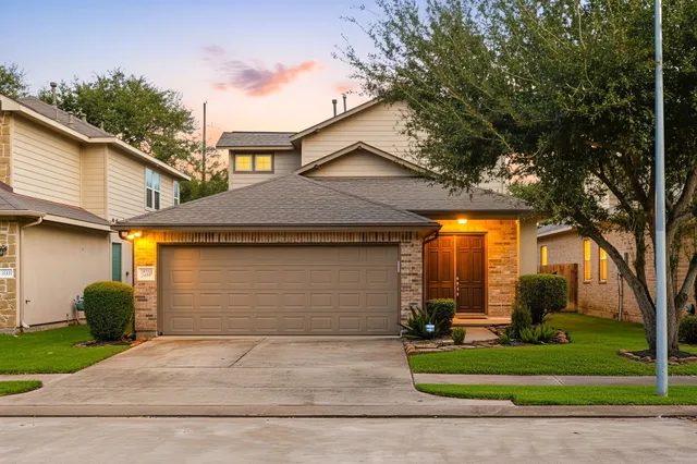 a front view of a house with a yard and garage