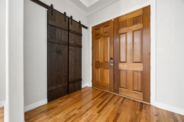 an empty room with wooden floor and mirror