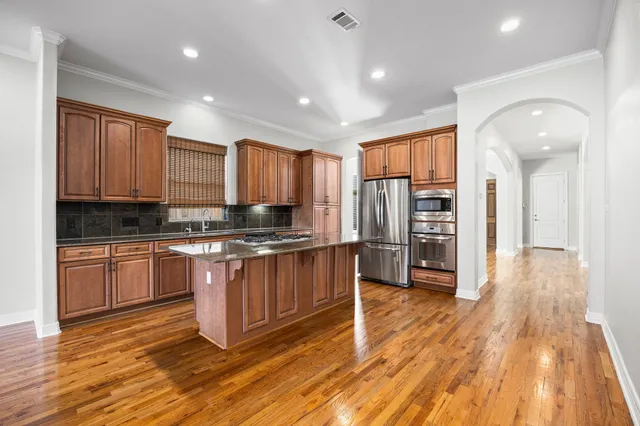 a large kitchen with stainless steel appliances granite countertop a stove and a refrigerator