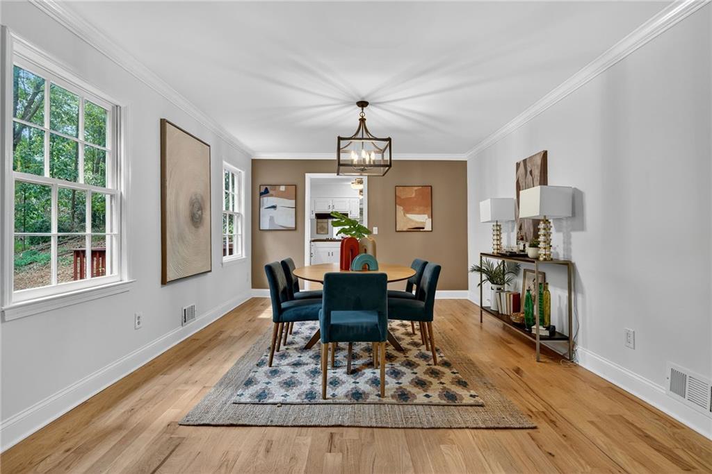7565 Ball Mill Road Northeast Atlanta, GA 30350 - Photo 21 of 61 a dining room with wooden floor a chandelier a wooden table and chairs