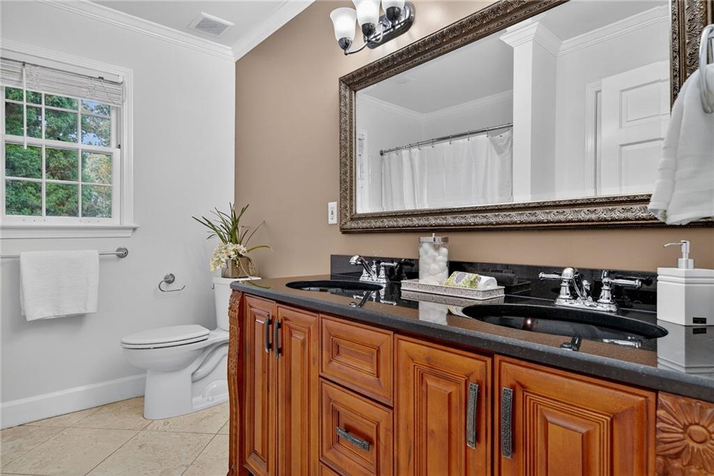 7565 Ball Mill Road Northeast Atlanta, GA 30350 - Photo 54 of 61 a bathroom with a granite countertop sink a toilet and a mirror
