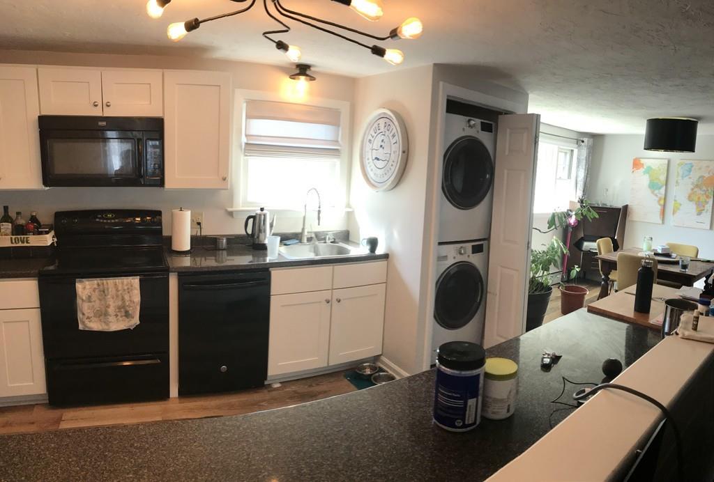 154 Ravenswood Road Waltham, MA 02453 - Photo 3 of 11 a kitchen with sink a stove and chairs