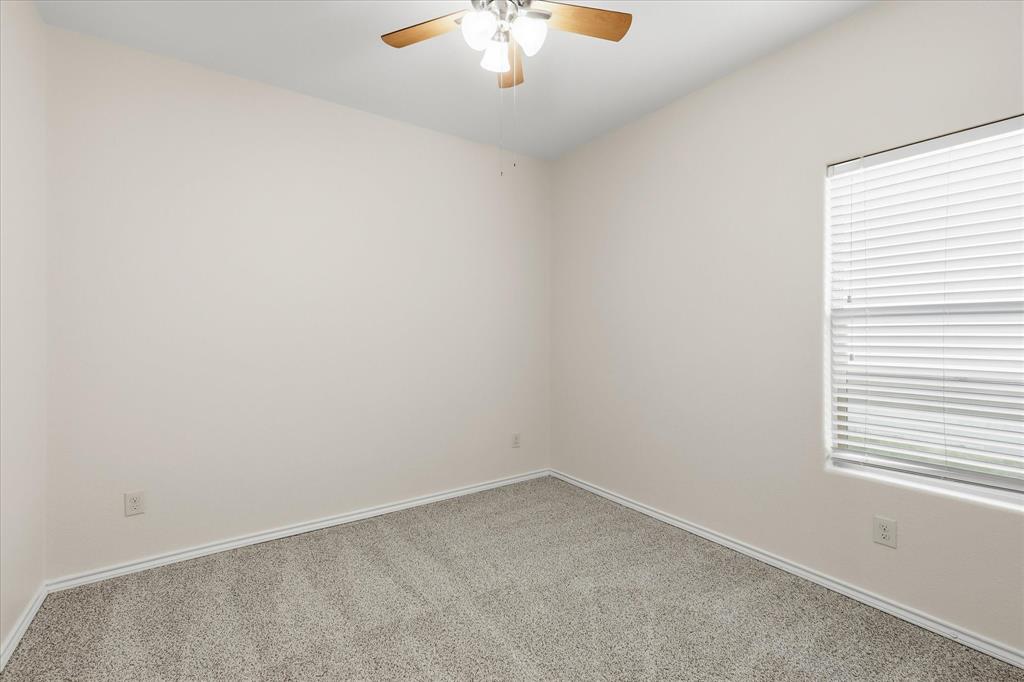720 Rio Bravo Drive Fort Worth, TX 76052 - Photo 28 of 38 Room featuring neutral wall tones, gray carpet, white trim, and a ceiling fan with light fixture