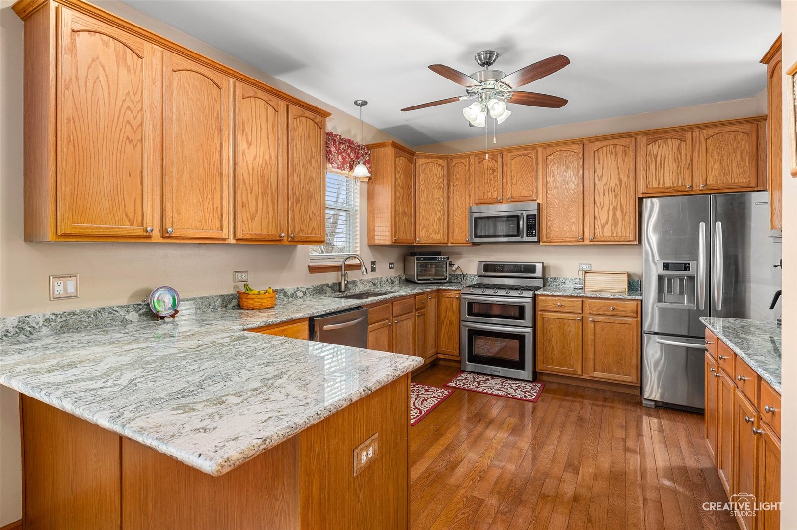 7651 Pin Oak Court Plainfield, IL 60586 - Photo 7 of 31 a kitchen with granite countertop a stove top oven a sink dishwasher and a refrigerator with wooden floor