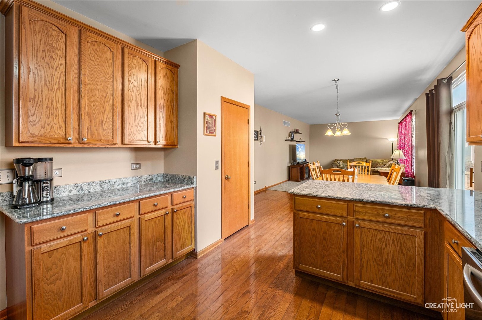 7651 Pin Oak Court Plainfield, IL 60586 - Photo 8 of 31 a kitchen with stainless steel appliances granite countertop wooden cabinets a sink and dishwasher with wooden floor