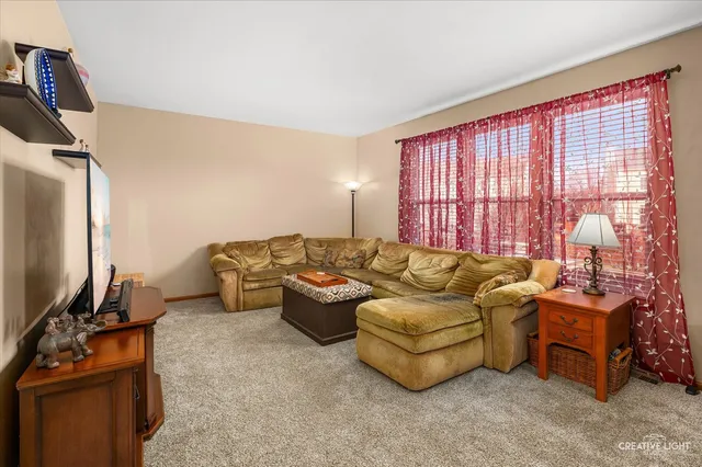 a living room with furniture a flat screen tv and a window