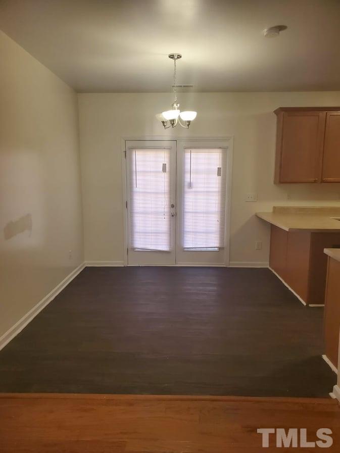 2533 Friendly Trail Raleigh, NC 27610 - Photo 6 of 20 an empty room with windows and chandelier
