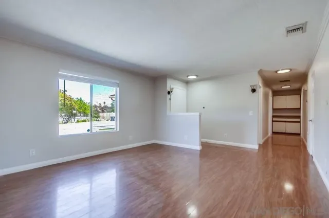 an empty room with wooden floor and a window