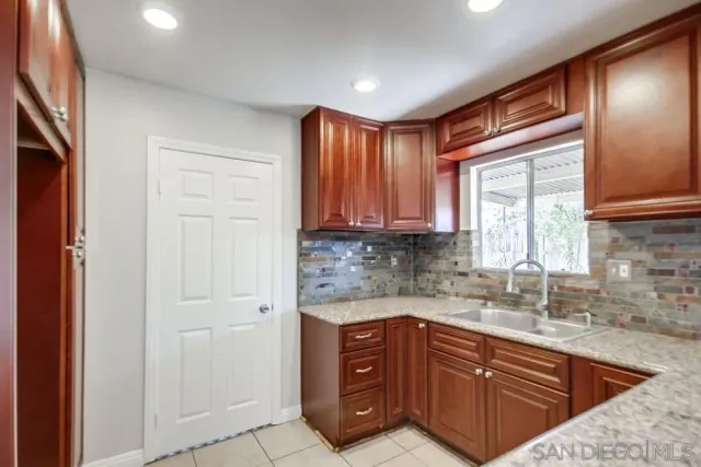 a kitchen with stainless steel appliances granite countertop a sink and cabinets with wooden floor