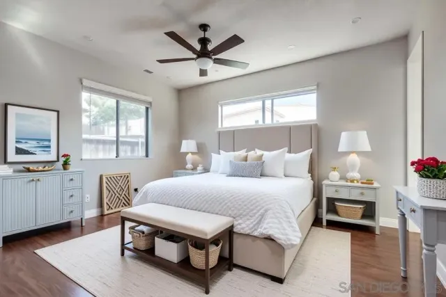 a bedroom with a bed a chandelier and a dresser