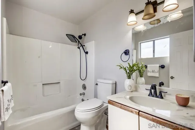 a bathroom with a granite countertop sink a toilet and a mirror