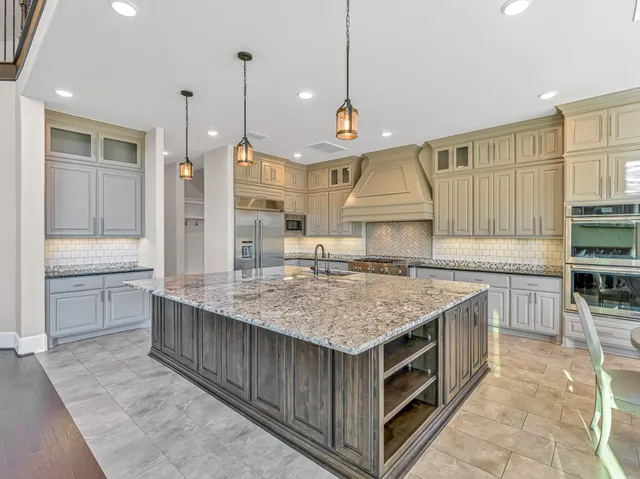 a kitchen with kitchen island a counter top space a sink stainless steel appliances and cabinets