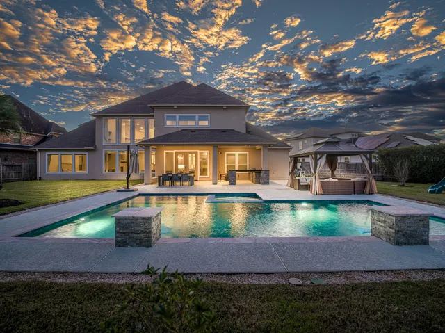a view of an house with swimming pool and a yard