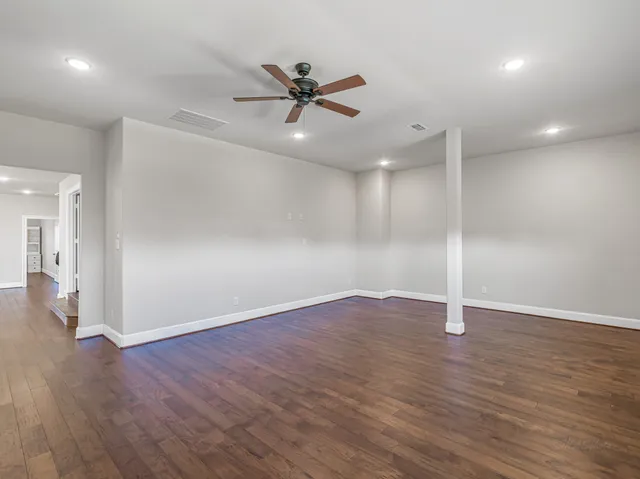 a bedroom with a bed and a table with wooden floor