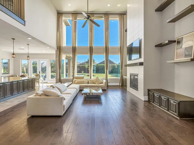 a living room with furniture and a large window with wooden floor