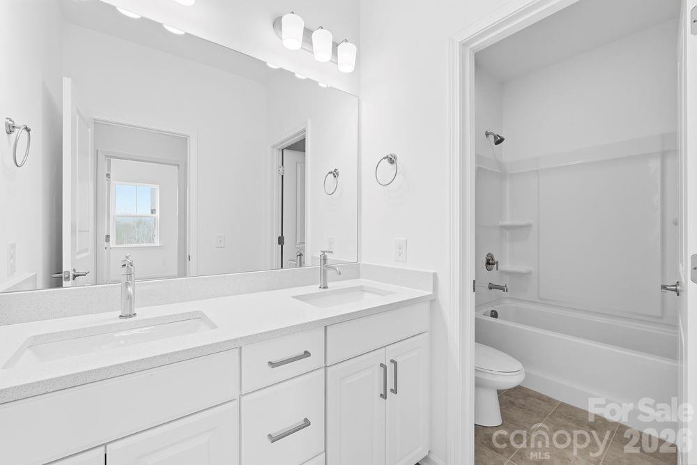 8668 Miles Gap Road Indian Land, SC 29707 - Photo 14 of 28 a bathroom with a sink double vanity granite tub and shower