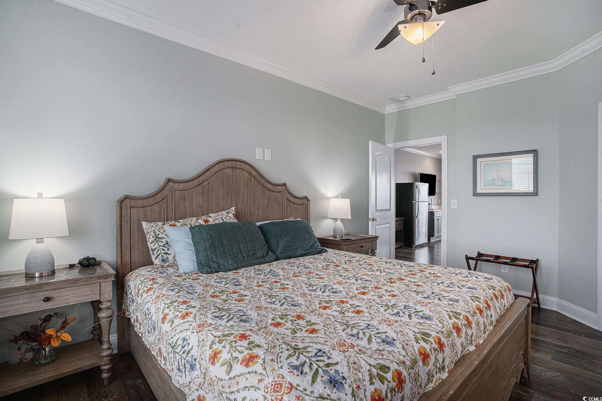 1907 South Waccamaw Drive Murrells Inlet, SC 29576 - Photo 20 of 40 Bedroom with crown molding, dark hardwood / wood-style floors, ceiling fan, and stainless steel refrigerator