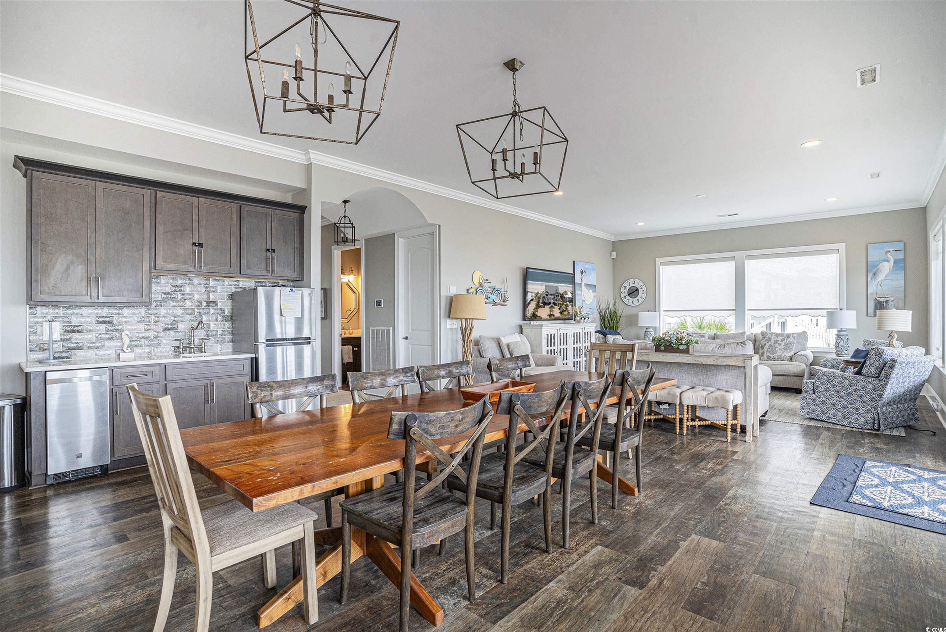 1907 South Waccamaw Drive Murrells Inlet, SC 29576 - Photo 10 of 40 Dining room featuring ornamental molding, an inviting chandelier, and dark hardwood / wood-style floors