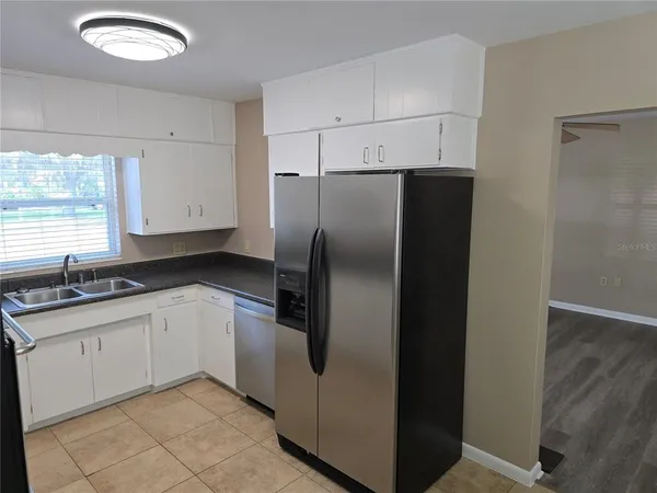 a kitchen with stainless steel appliances granite countertop a refrigerator and a sink