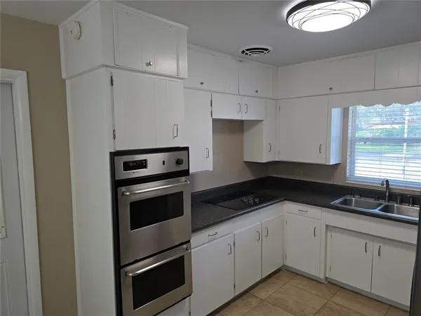 a kitchen with granite countertop white cabinets and white appliances