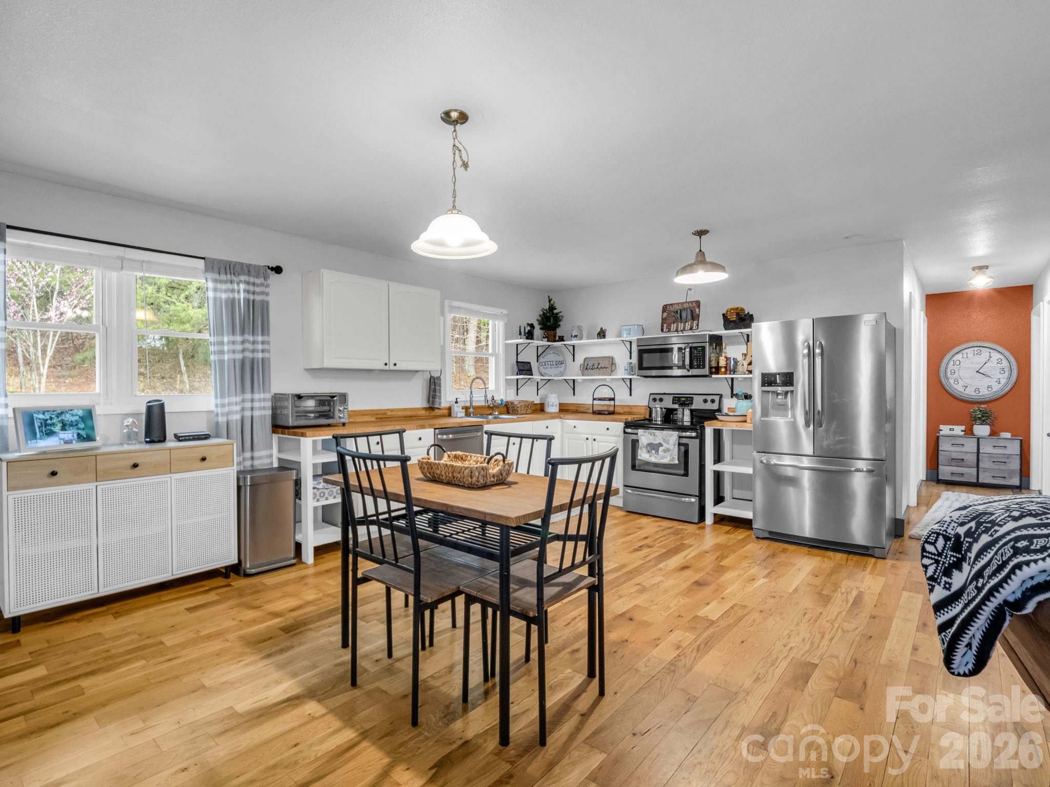 248 Bible School Road Lake Lure, NC 28746 - Photo 15 of 38 a kitchen with stainless steel appliances kitchen island granite countertop a table chairs sink and cabinets