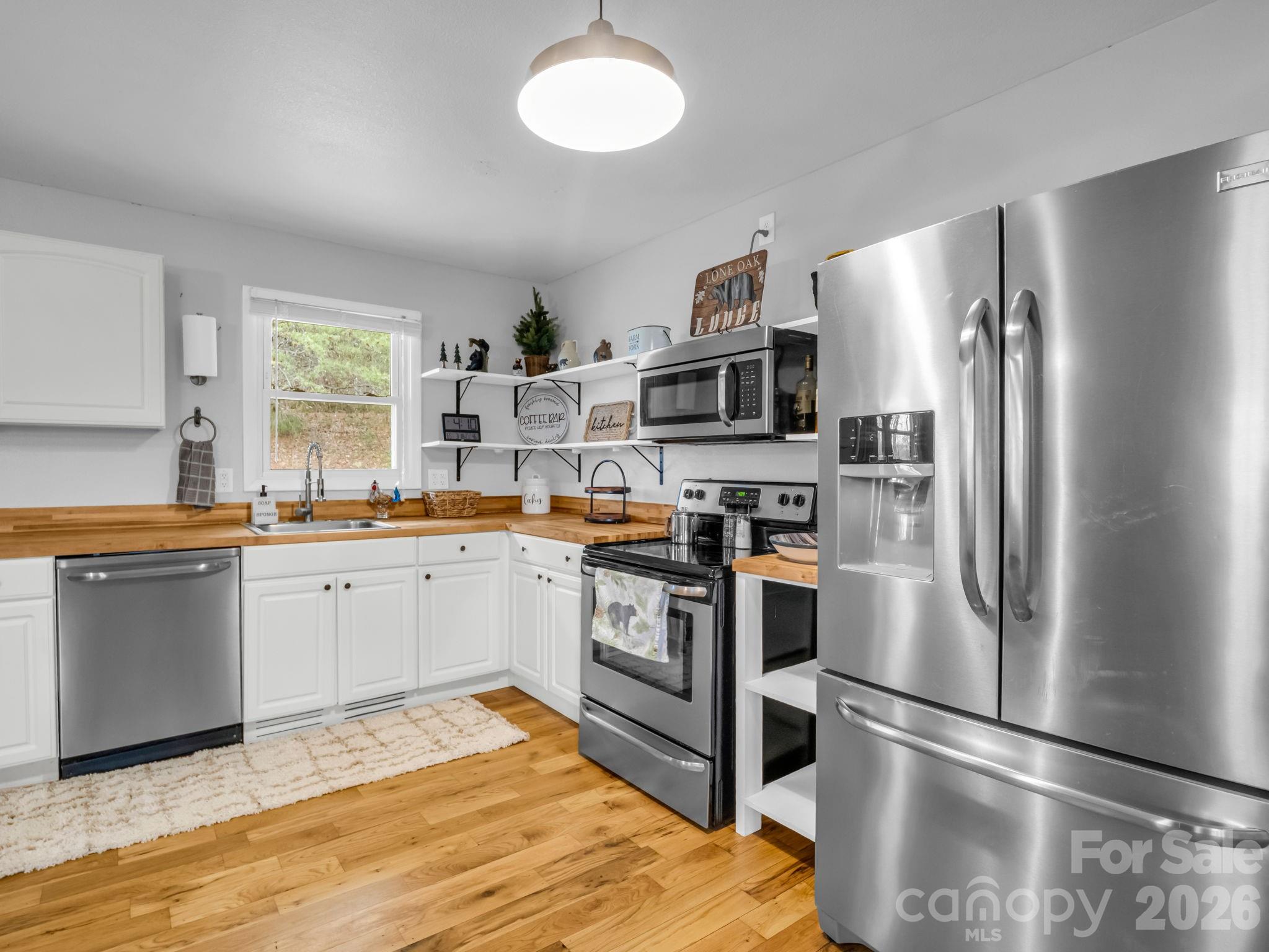 248 Bible School Road Lake Lure, NC 28746 - Photo 20 of 38 a kitchen with stainless steel appliances a refrigerator sink and microwave