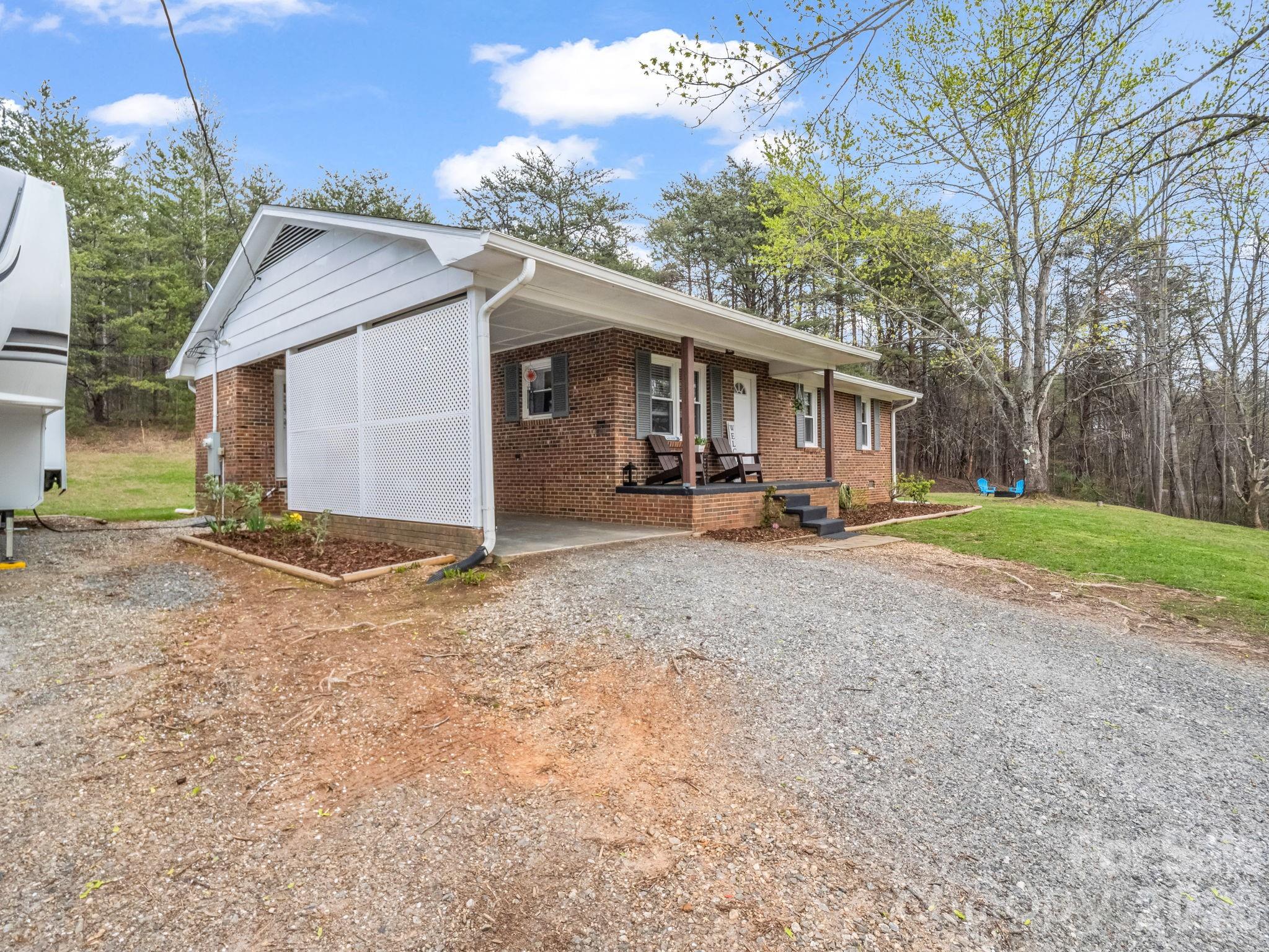 248 Bible School Road Lake Lure, NC 28746 - Photo 2 of 38 a front view of a house with a yard and garage