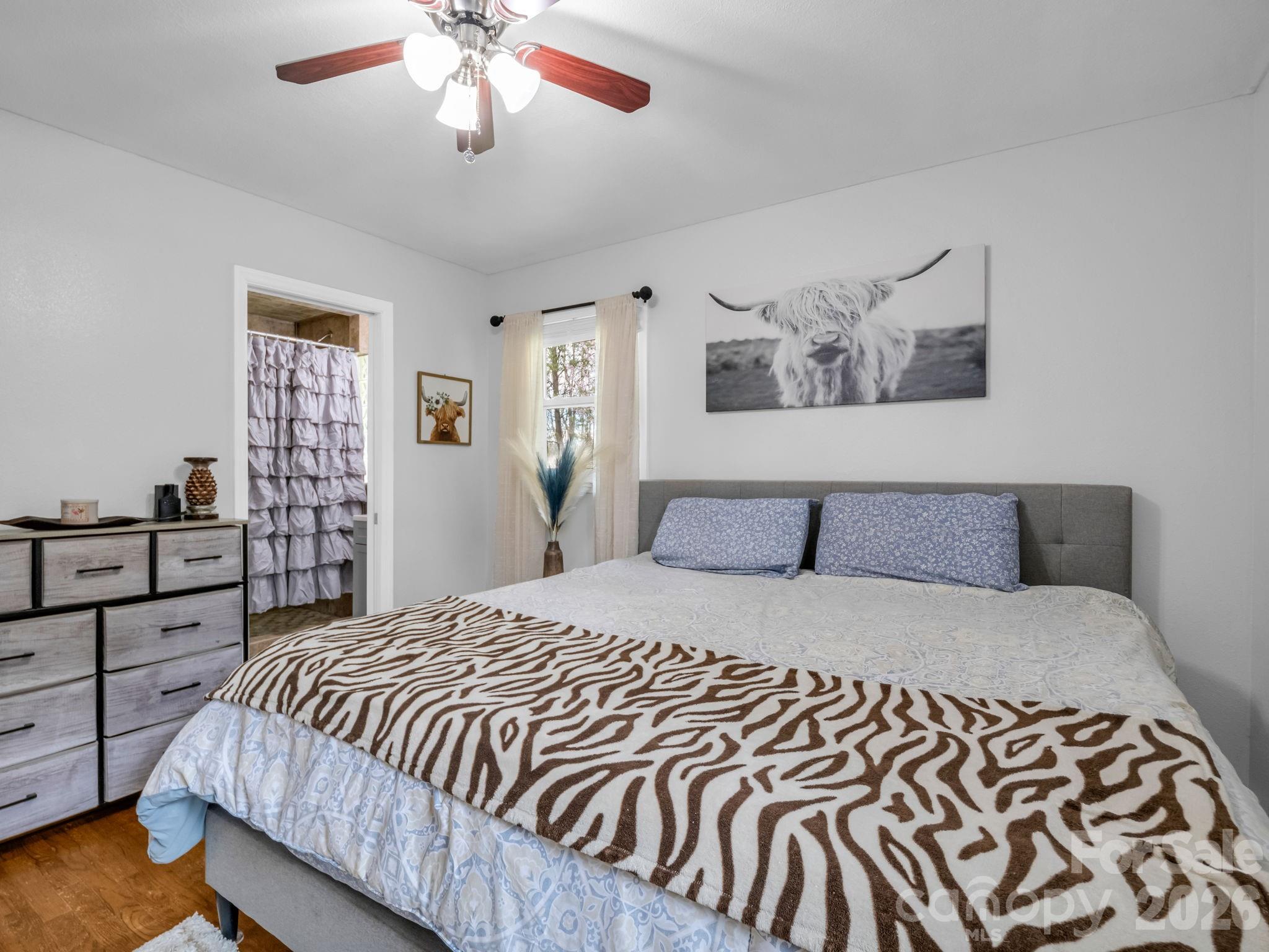 248 Bible School Road Lake Lure, NC 28746 - Photo 31 of 38 a bedroom with a large bed and a chandelier