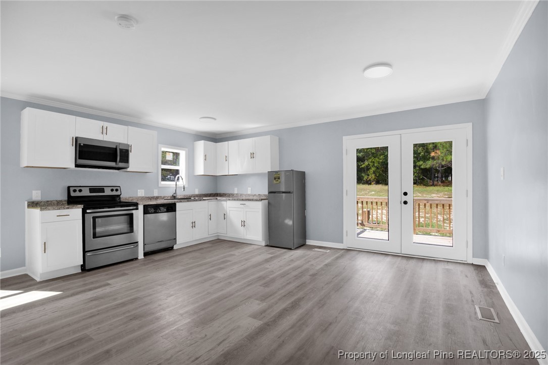 258 Brower Road Cameron, NC 28326 - Photo 9 of 24 a kitchen with wooden floors and white appliances
