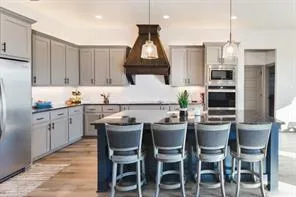 a kitchen with a dining table chairs cabinets and stainless steel appliances