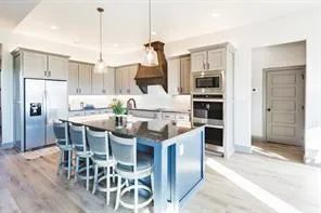 a kitchen with stainless steel appliances kitchen island granite countertop a dining table chairs and granite counter tops