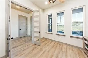 a view of empty room with wooden floor and fan
