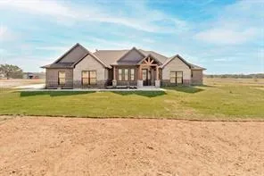 a view of a house with a big yard and large trees