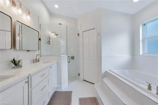 a bathroom with a tub sink and mirror