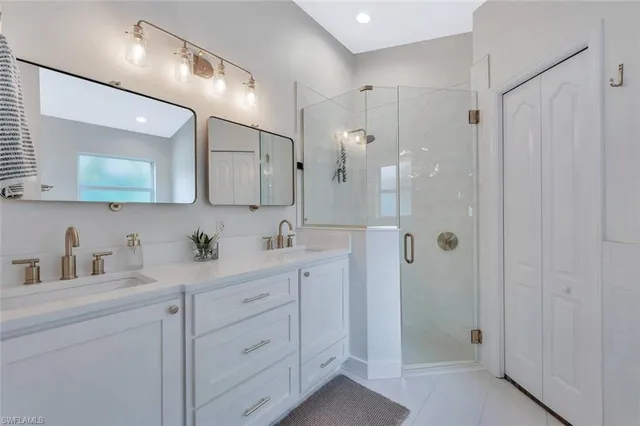 a bathroom with a double vanity sink mirror and shower